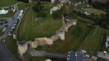 Falaise Şatosu 'nun şaşaalı mimarisini keşfedin. Yeşilliklerle çevrili. Şato bulutlu gökyüzüne karşı görkemli bir şekilde duruyor, büyüleyici bir yaz atmosferi yaratıyor..