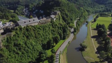 Bu video, Belçika 'nın Bouillon kentindeki Semois Nehri' ne bakan bir uçurumun tepesindeki ortaçağ kalesi olan Chateau Kalesi 'nin çarpıcı hava manzarasını sergiliyor.