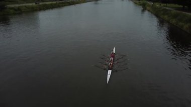 Gent 'in göbeğinde, kendini adamış bir ekip sakin sularda süzülerek takım çalışmasını ve hassasiyetini sergiliyor. Sabahın erken saatleri alıştırmaları için barışçıl bir ortam yaratır..