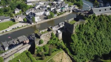 Bouillon Kalesi 'nin nefes kesici hava manzarası, Belçika' nın Bouillon kentindeki Semois nehrine bakan kayalık bir uçuruma tünemişti. Video, kalelerin heybetli yapısını, kıvrımlı nehri ve çevresini saran yemyeşil manzarayı sergiliyor..