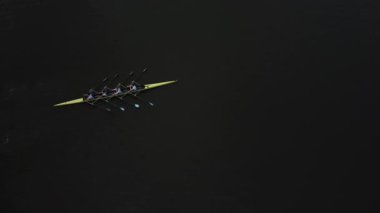 Küçük bir ekip Gent 'in sakin sularında senkronize bir uyum içinde kürek çekerek sabah ışığı yüzeyden yavaşça yansıyarak eğitimleri için barışçıl bir atmosfer yaratıyor..