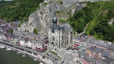 Belçika 'nın çarpıcı Dinant' ının hava manzarası. İkonik kilise dimdik, kıvrımlı nehre bakıyor ve nehir kıyısında renkli evler var..