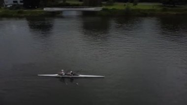 Gent 'in sakin sularında zarif bir şekilde süzülen iki kürekçi, bu güzel manzarada, çevrelerinin huzurlu güzelliğinin tadını çıkarırken mükemmel bir senkronizasyon sergiliyor..