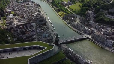 Belçika 'nın Dinant kentinin, Meuse Nehri' nin şehirde dolaştığını gösteren hava manzarası. Şehrin iki tarafını birbirine bağlayan bir köprü var..