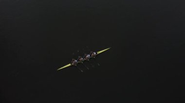 Sabahın erken saatlerinde, bir kürek ekibi Gent 'in sakin sularında sakin bir güzellikle süzülüyor. Ritmik hareket ve takım çalışması büyüleyici bir gösteri yaratır..