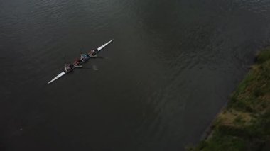 Ekip, takım çalışmalarını ve yeteneklerini sergileyerek Gent 'in sakin sularında ustaca geziniyor. Canlı şehir manzarası, suyu keserken çarpıcı bir zemin oluşturuyor..