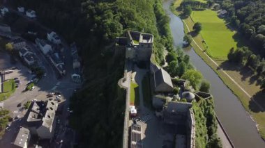 Bu hava görüntülerinde Belçika 'nın Bouillon şehrinde bulunan Kasteel van Bouillon sergilenmektedir. Video, heybetli kaleleri, çevreleyen yemyeşil alanları ve yakında akan kıvrımlı nehri yakalar.