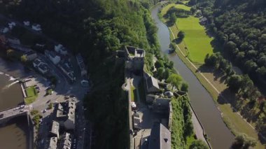 Bu video, Kasteel van Bouillon ve etrafındaki Bouillon Vadisi 'nin çarpıcı hava manzarasını gösteriyor. Görüntüler vadiyi, görkemli şatoyu ve içinden akan kıvrımlı nehri görüntülüyor..