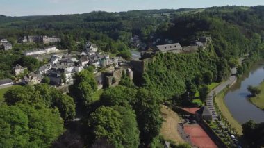 Bu video, yemyeşil tepelerin arasına yerleşmiş büyüleyici Belçika kasabası Bouillon 'un nefes kesici hava manzarasını gösteriyor. Video, kentler, tarihi binalar, çevre ormanlar ve dolambaçlı nehir de dahil olmak üzere resimsel manzarayı yakalar..