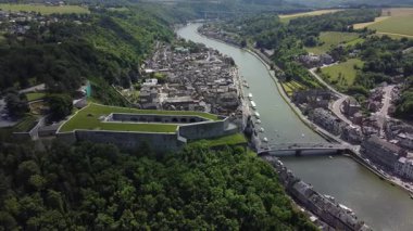 Dinant Kalesi 'nin çarpıcı hava manzarası, Meuse Nehri' ne bakan bir uçurumun tepesine tünemiş tarihi bir kale. Dinant kasabası, büyüleyici evleri ve kaldırımlı caddeleriyle aşağıya doğru yayılıyor..