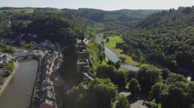 Bouillon şehrinin nefes kesici hava manzarası ve Belçika 'nın görkemli şatosu de Bouillon Kalesi. Çevredeki yeşil tepelerin panoramik manzarasının, dolambaçlı nehrin ve aşağıdaki kasabanın büyüleyici mimarisinin tadını çıkarın..