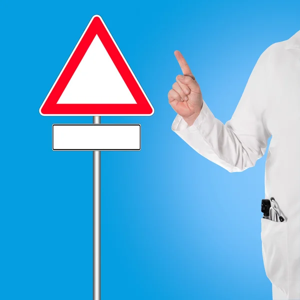 Doctor holding thumbs up, and pointing to a sign — Stock Photo, Image