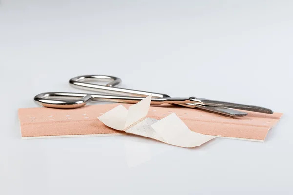 Plaster bandage roll and scissors — Stock Photo, Image