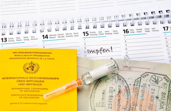 疫苗接种证书和日历上附有疫苗接种日期的护照 免版税图库图片