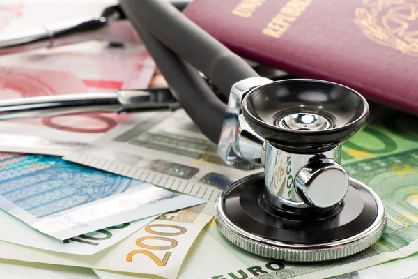 Bills with stethoscope and passport — Stock Photo, Image