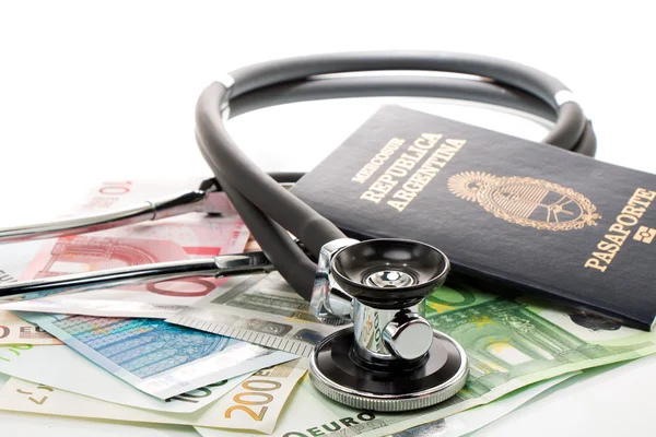 Bills with stethoscope and passport — Stock Photo, Image