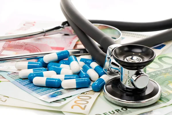 Bills with stethoscope and tablets, pills — Stock Photo, Image