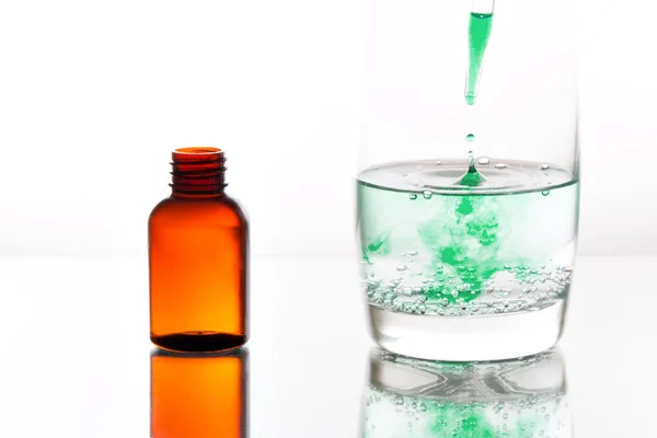 Medicine dropping into a glass of water — Stock Photo, Image