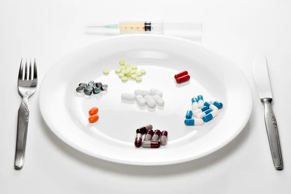 Таблетки на белой тарелке — стоковое фото