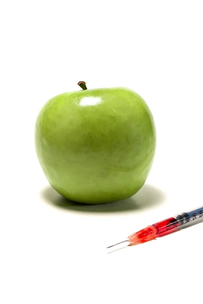 Zelené jablko s injekční stříkačkou — Stock fotografie