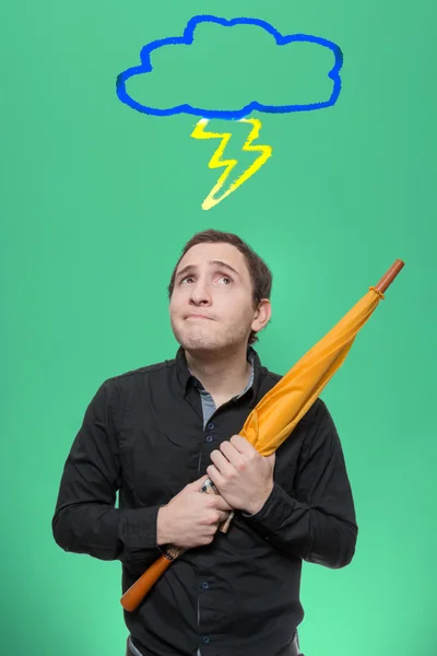 Young Man with umbrella looking up on a rain cloud thundercloud — 스톡 사진