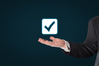 Bir kontrol simgesi tutan işadamı