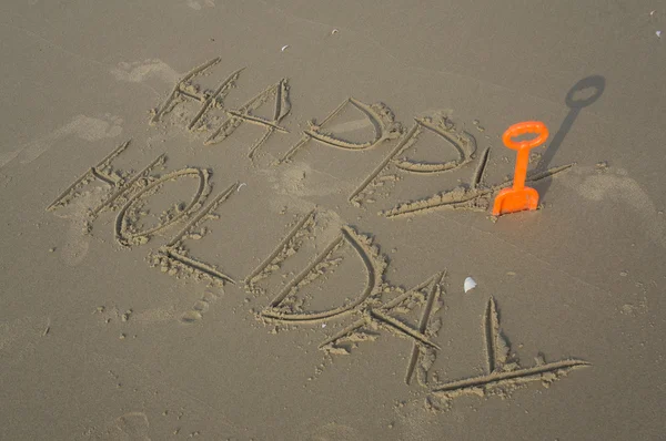 Happy holiday write on sand tool toy — Stock Photo, Image