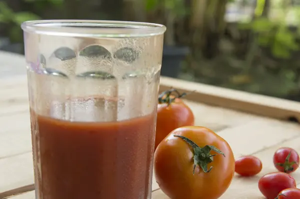 Suco de tomate fresco na mesa de madeira — Fotografia de Stock