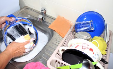 Kadın mutfakta bulaşık yıkıyor..