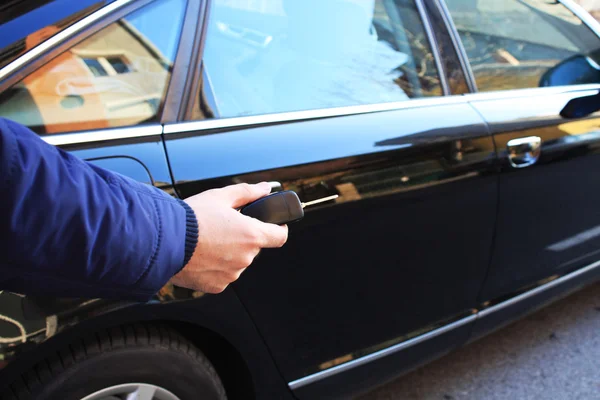 Young man opening car with a key — Stock Photo, Image