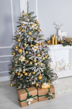 Beyaz bir odada hediyeleri olan büyük bir Noel ağacı