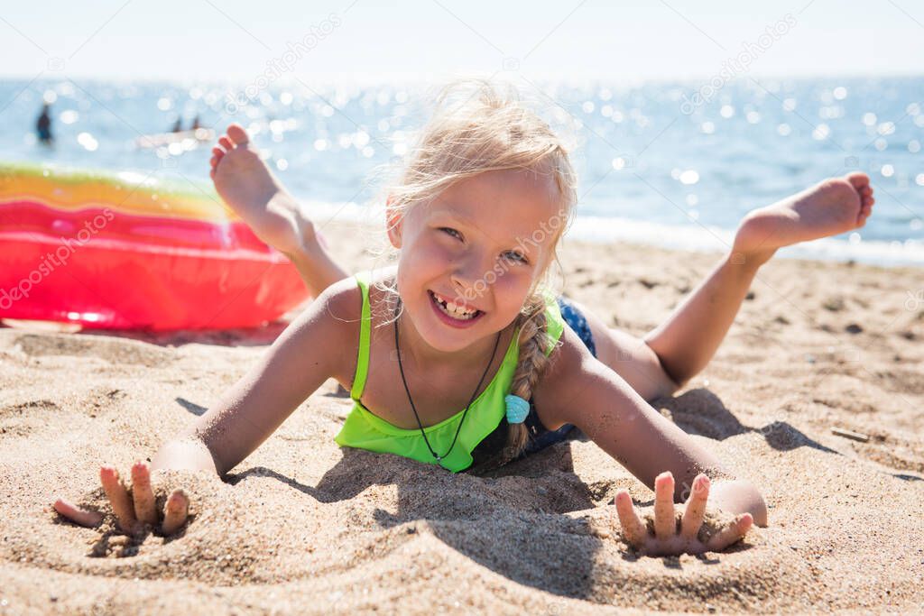 Portrait of little girl with inflatable rubber circle on beach