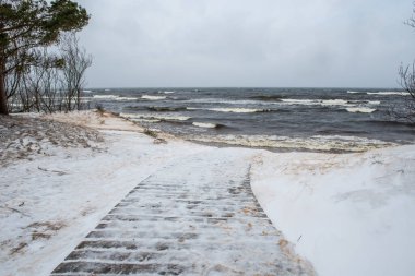 Baltık Denizi sahilleri kışın karlıdır ve denizde büyük dalgalar vardır. Letonya 'nın Saulkrasti kentindeki Baltık Denizi' nin kumulları arasındaki patika