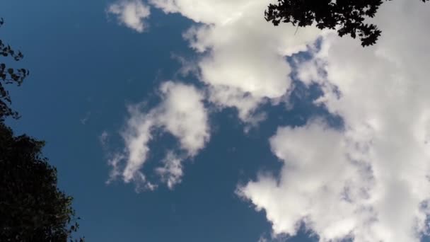 Nubes moviéndose a través del cielo azul brillante — Vídeo de stock