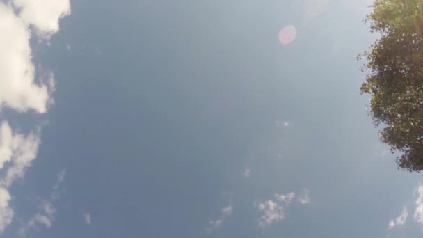 Nubes moviéndose a través del cielo azul brillante — Vídeo de stock