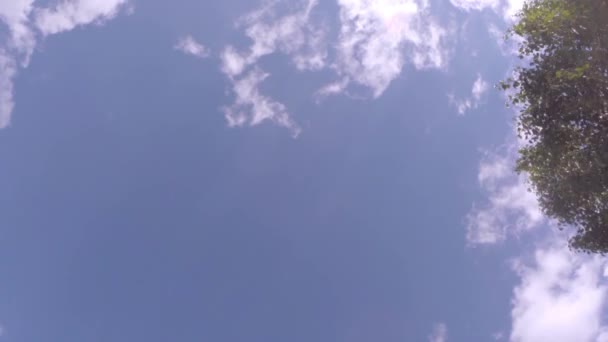 Nubes moviéndose a través del cielo azul brillante — Vídeo de stock