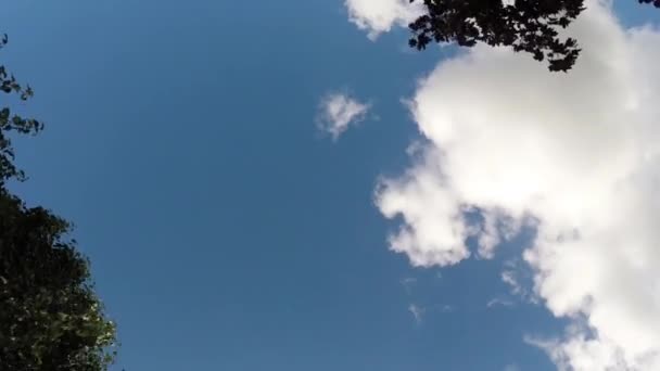 Nubes moviéndose a través del cielo azul brillante — Vídeo de stock