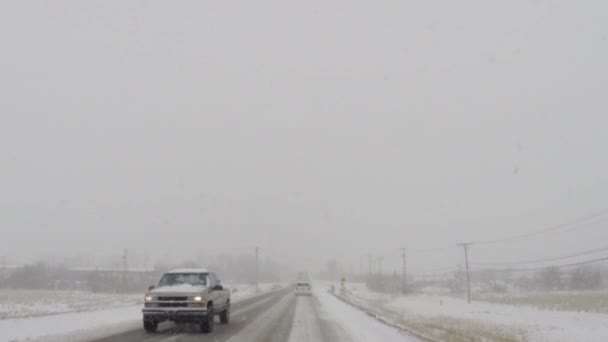 Вождение автомобиля по скользким дорогам во время холодной зимней снежной бури — стоковое видео