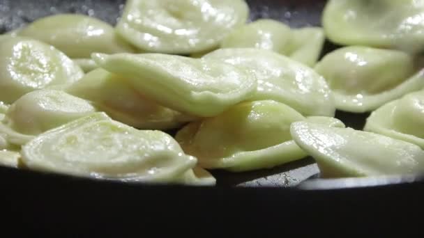 Cooking perogi dumplings in frying pan on stovetop oven — Stock Video