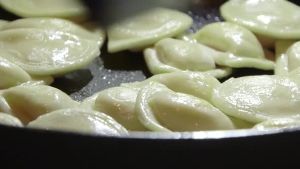 Cooking perogi dumplings in frying pan on stovetop oven — Stock Video