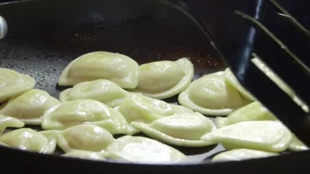 Koken perogi dumplings in koekenpan op stovetop oven — Stockvideo