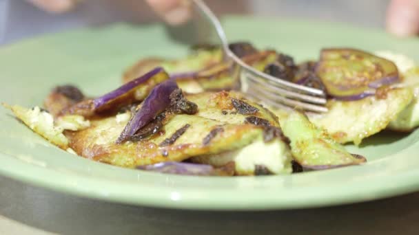 Hombre comiendo filete de pescado con un tenedor en la cocina — Vídeos de Stock