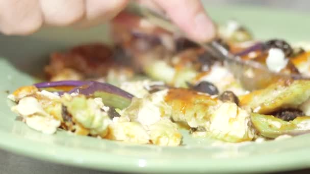 Man eating fish fillet with a fork in kitchen — Stock Video