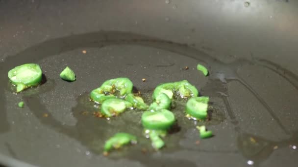 Jalapeno peppers with olive oil in frying pan — Stock Video