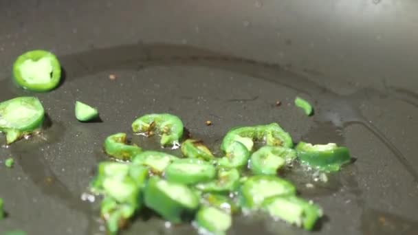 Jalapeno peppers with olive oil in frying pan — Stock Video