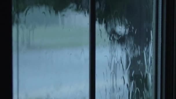 Падіння дощу, що тече вниз віконним склом — стокове відео