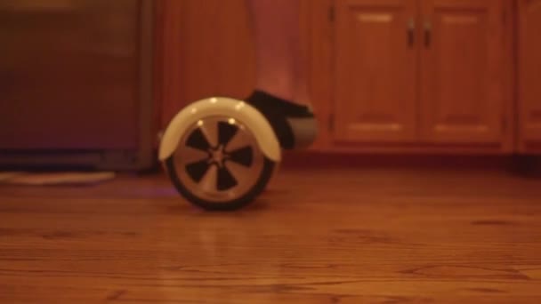Menino montando uma scooter de equilíbrio elétrico de duas rodas — Vídeo de Stock