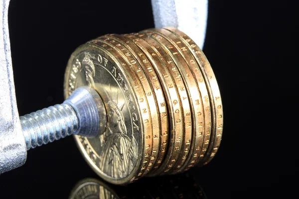 Προϋπολογισμός κρίση μας νόμισμα χρυσά νομίσματα σε Vise σφιγκτήρας — Φωτογραφία Αρχείου