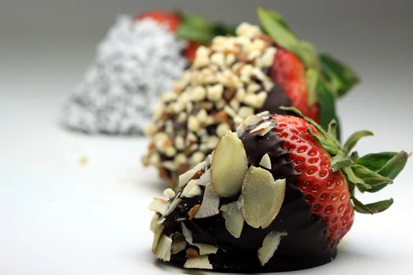 Strawberry dipped in chocolate covered with almond nuts — Stock Photo, Image