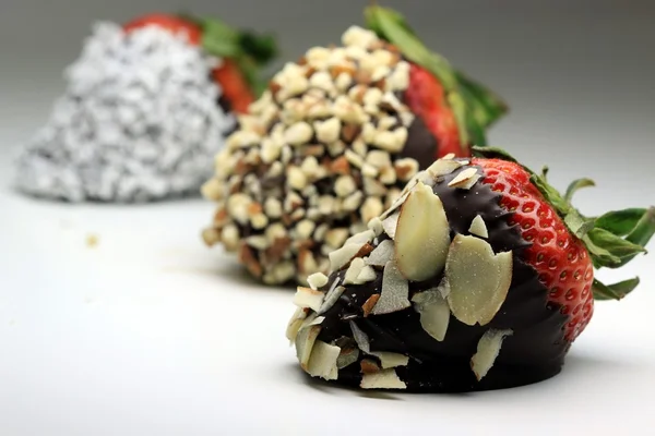 Strawberry dipped in chocolate covered with almond nuts — Stock Photo, Image